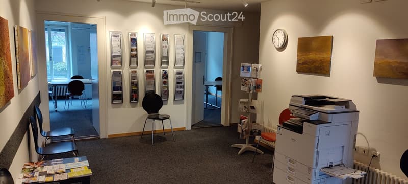 Furnished Room. Office space with chairs, tables, a printer, and artwork on the walls.