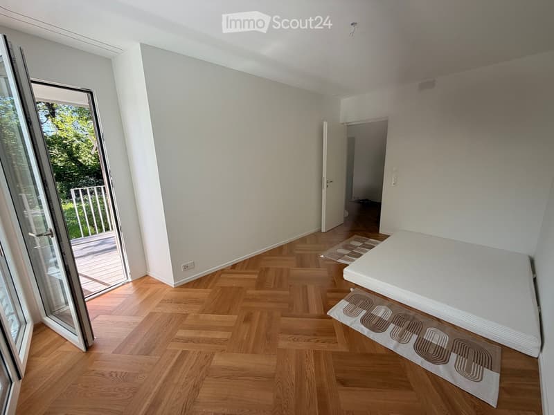 Unfurnished Room. Empty room with wooden flooring, white walls, and a sliding glass door leading to a balcony.