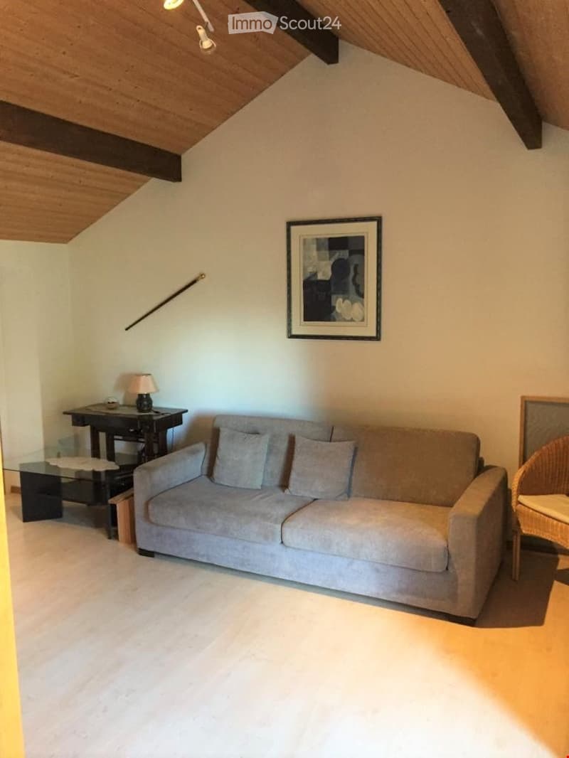Living Room. Living room with a grey sofa, small table, chair, lamp, and picture frame on the wall.