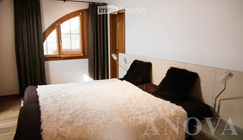 Wooden floor, double bed, large window, dark brown pillow, white duvet