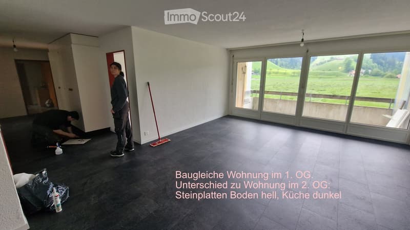 Unfurnished Room. Empty room with dark tiled floor, large windows overlooking a green landscape, and a partially visible doorway. No furniture or equipment present.