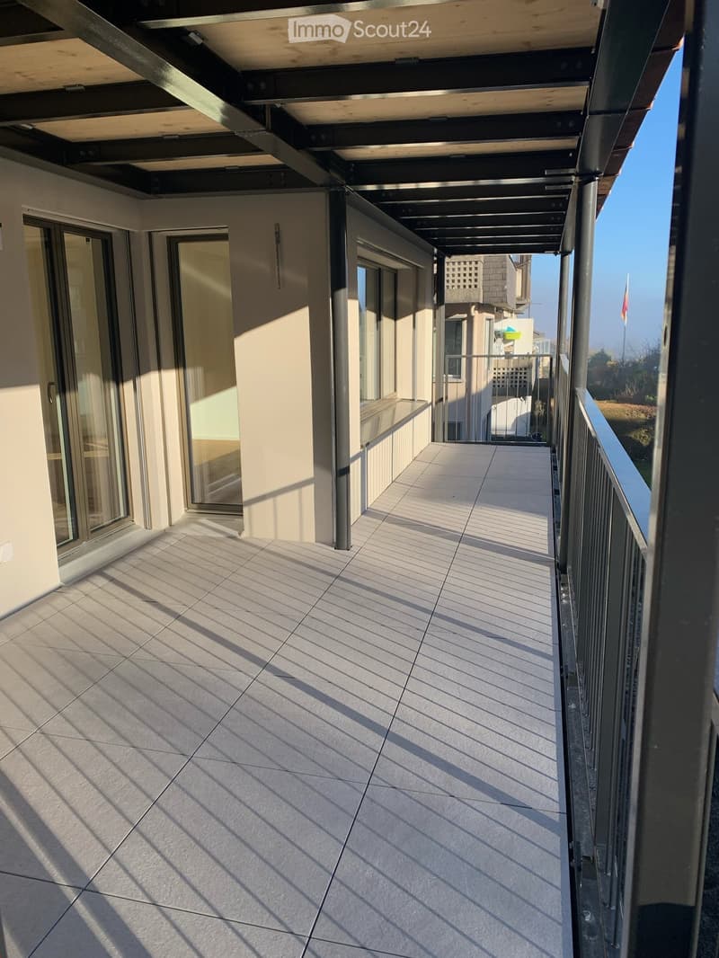 Balcony with tiled floor, metal railing, and glass doors leading to the interior.