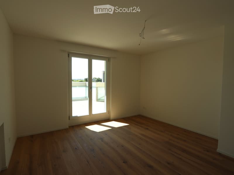 Unfurnished Room. Empty room with wooden flooring, white walls, and large sliding glass doors leading to a balcony.