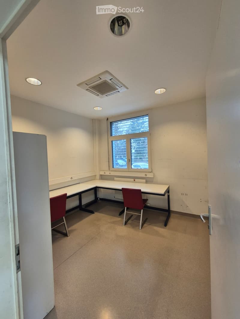 empty room with a desk, two chairs, window, and air conditioning unit