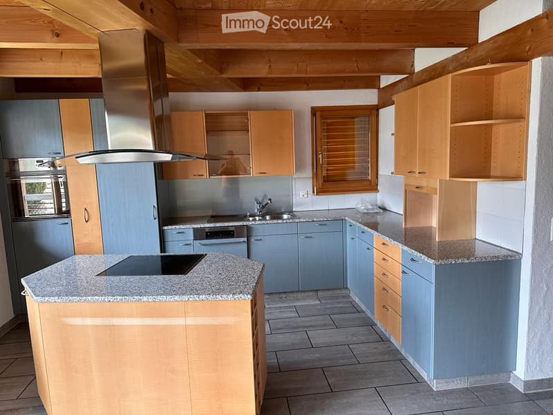 Kitchen. Modern kitchen with light wood cabinets, stainless steel appliances, granite countertops, and a central island with an induction cooktop.