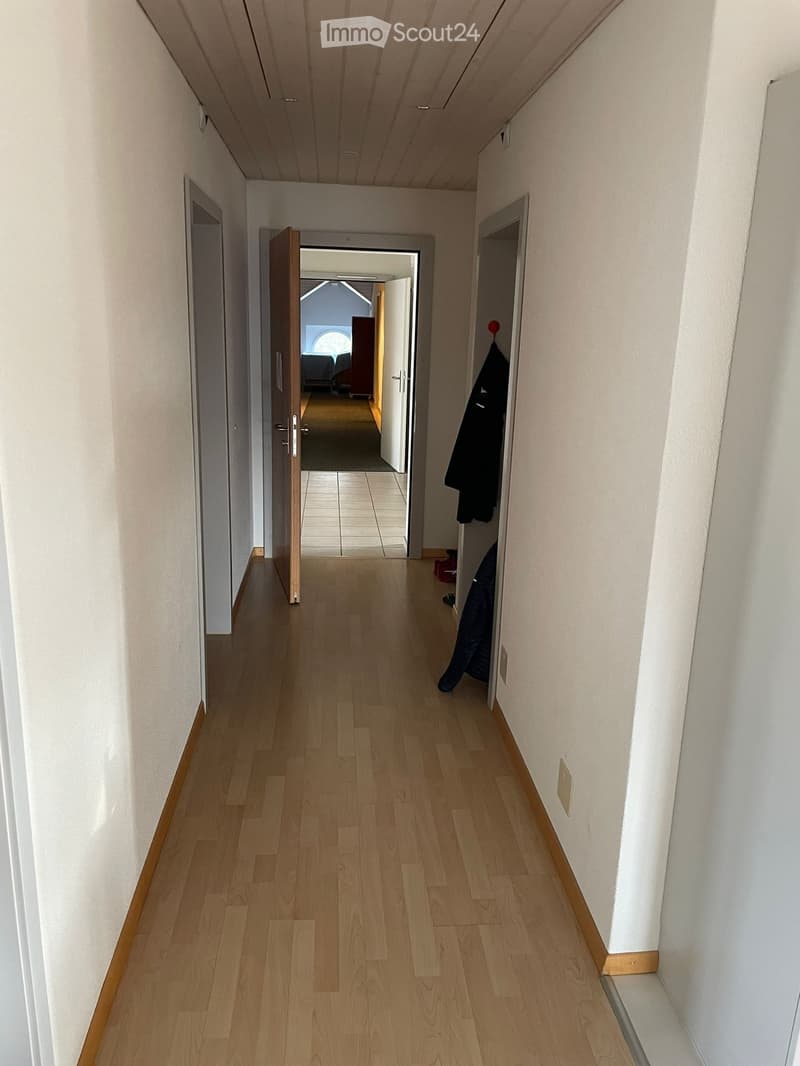 long hallway, wooden floor, white walls, doors on both sides