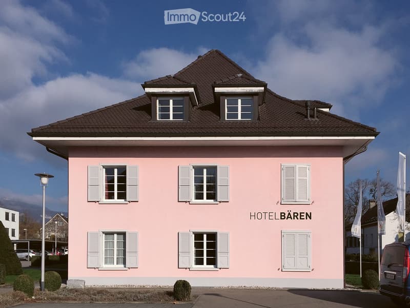 2 story building, pink exterior, white shutters, brown roof, labeled as Hotel Baren