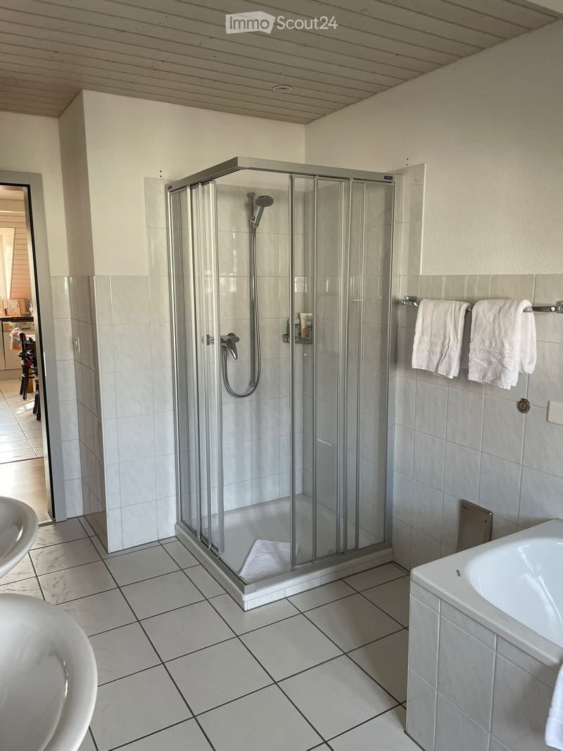 modern bathroom with shower, bathtub, white tiles, large windows, two sinks