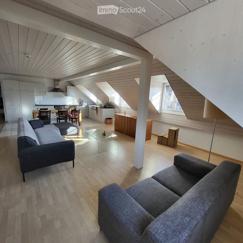 2 gray couches, glass table, white cabinets, wooden table with 4 chairs, open kitchen, small window, white flooring