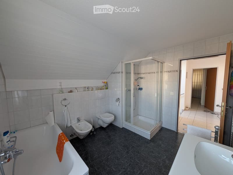 white bathtub, white bidet, white shower enclosure, white sink, tile flooring, white tiles on wall