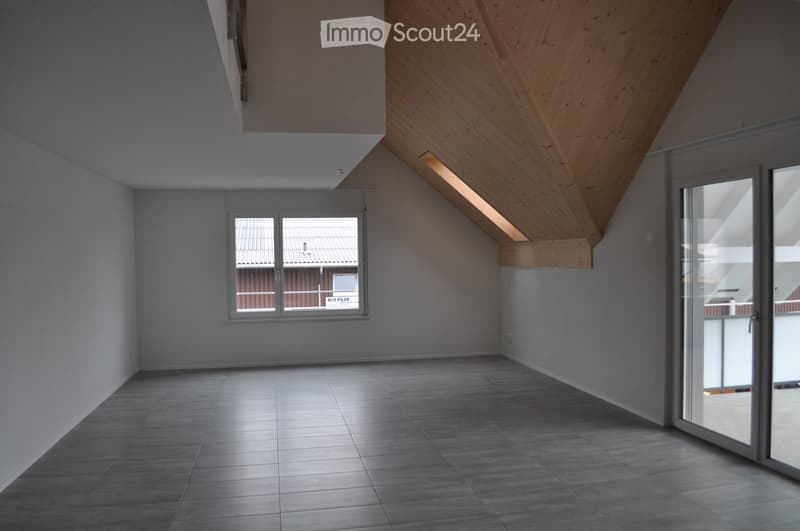 Empty room with grey tiled floor, white walls, large window, and sliding glass door leading to a balcony.