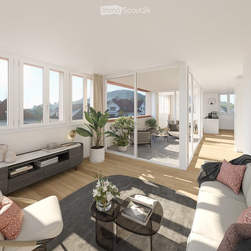 Modern living room with large windows offering a scenic view, featuring a grey sofa, coffee table, side table, bookshelf, and potted plants.