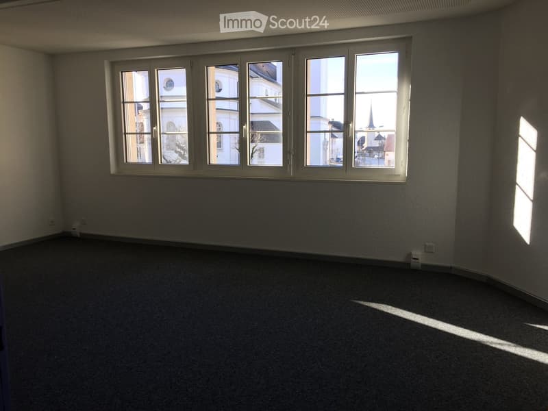 empty room with large windows and city view