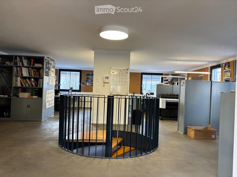 open layout, central spiral staircase, office equipment, bookshelves, ceiling lamps