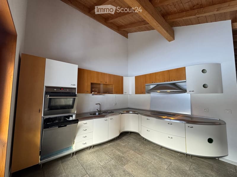 Modern kitchen with white and wooden cabinets, stainless steel appliances, and a sleek countertop.
