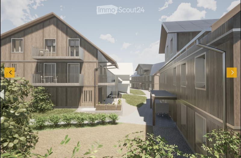 A modern residential complex with wooden facades, multiple balconies, and a central pathway surrounded by greenery.