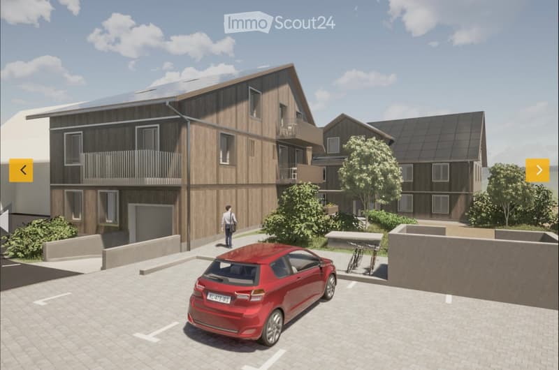 A modern two-story residential building with wooden facades, balconies, and solar panels on the roof. The scene includes a parking area with a red car, bicycles, and greenery.