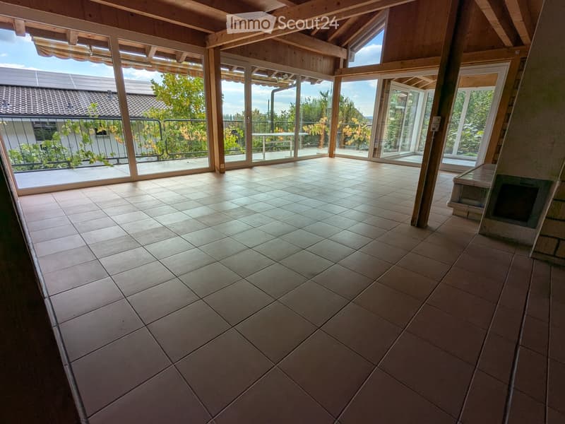 empty room with tiled floor, large sliding glass doors leading to balcony, wooden ceiling, fireplace