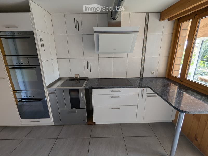 modern kitchen with stainless steel appliances, granite countertops, wooden wall panels, tiled flooring