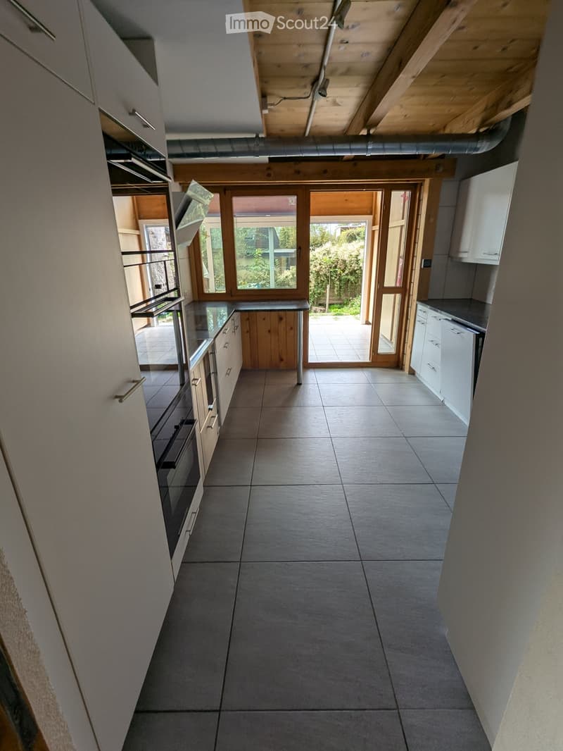 white cabinets, tiled floor, sliding doors leading to an outside patio, counter with stove top, built-in oven, kitchen island, open shelving