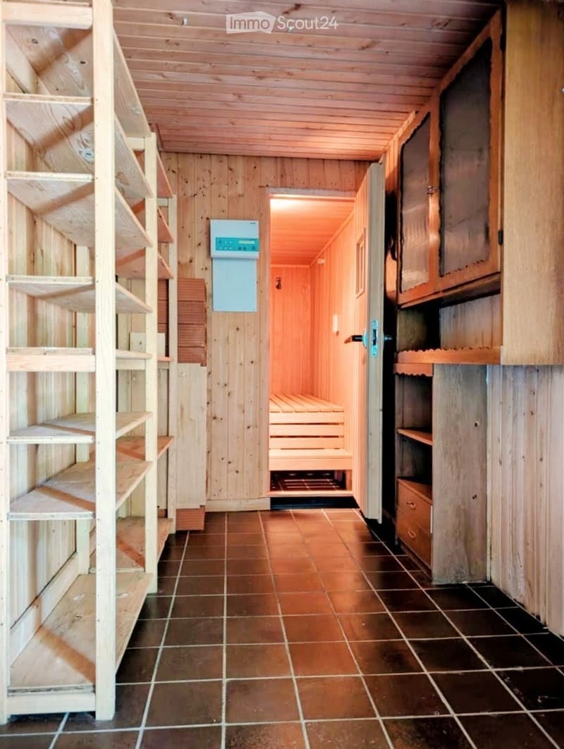 Wooden hallway with tiled floor, shelves, and a sauna area visible at the end.