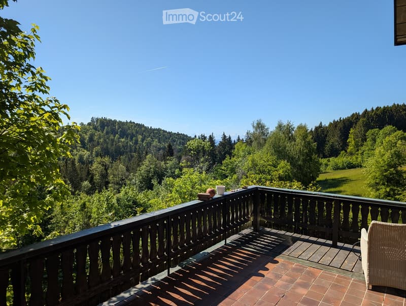 Balcony with wooden railing, tiled floor, and scenic mountain view.