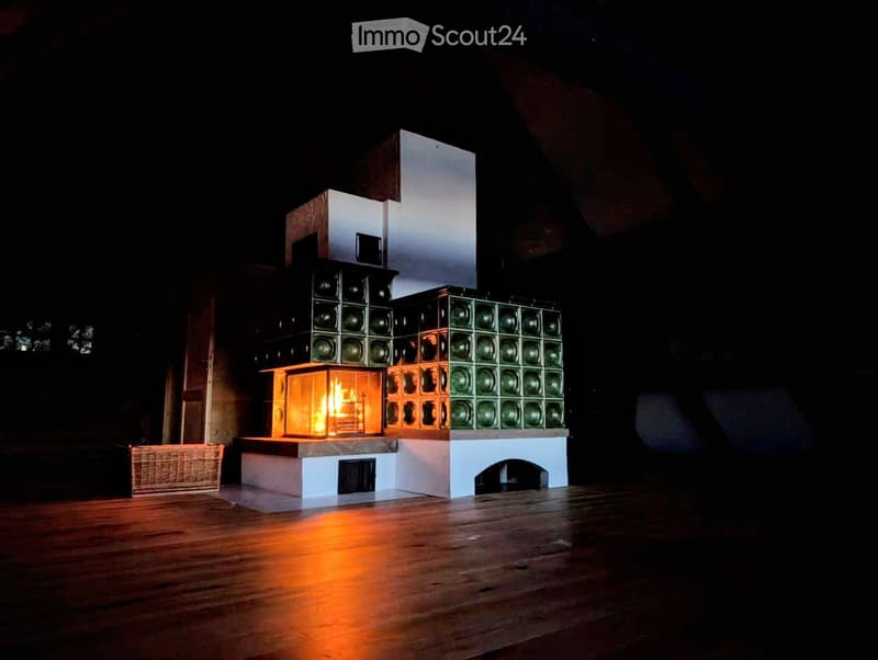 A modern fireplace with a geometric design, surrounded by a wooden floor and a wicker basket nearby.