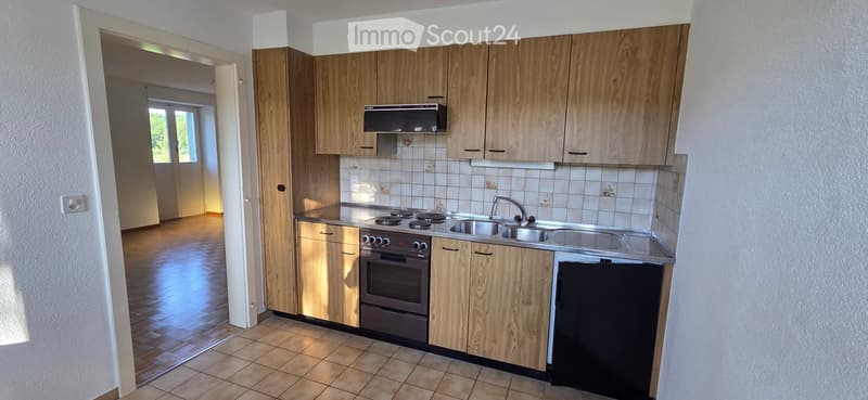 Modern kitchen with wooden cabinets, stainless steel appliances, and tiled backsplash. Features a stove, oven, sink, and dishwasher.