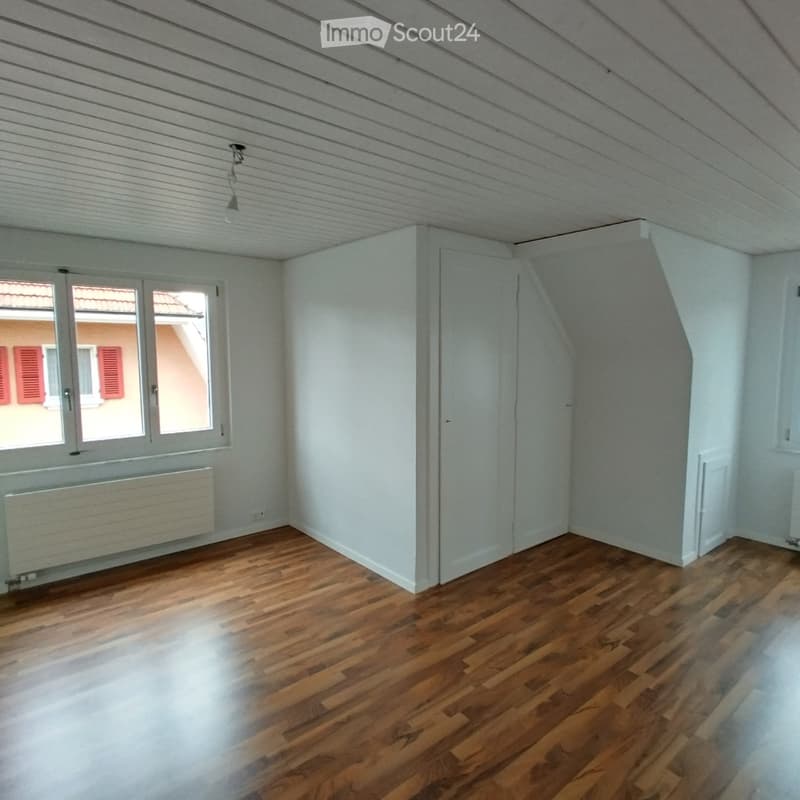 empty room with a window and a radiator