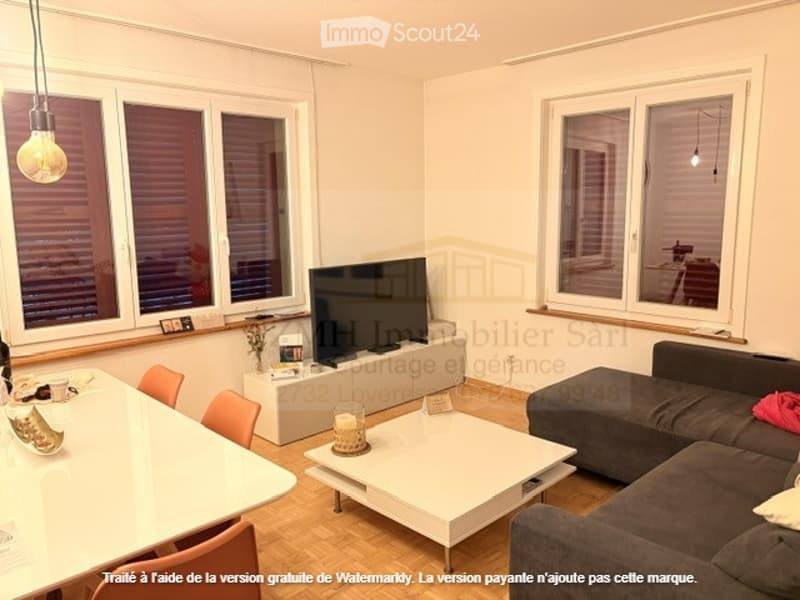 a TV, sofa, table, and chair in a living room