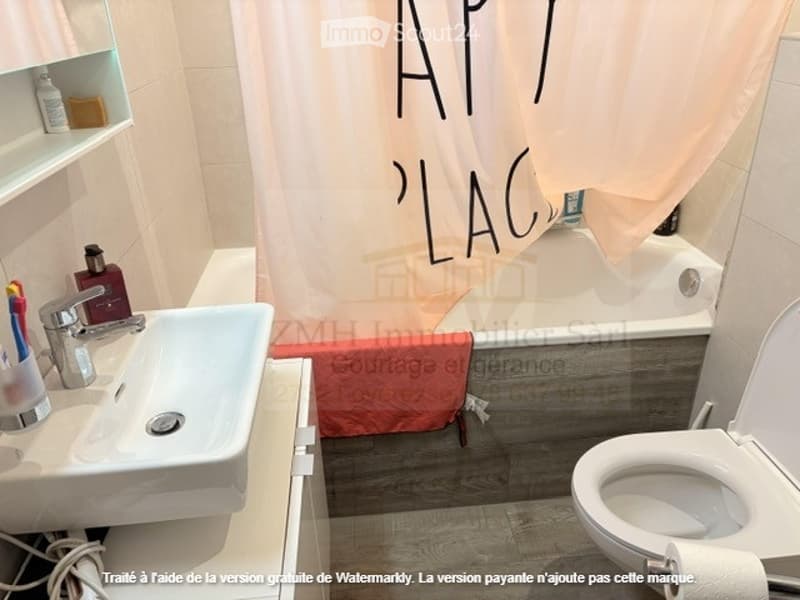 Bathtub, sink, countertop, faucet, toilet, shelves, curtain, tooth brushes, bottles, water bottles