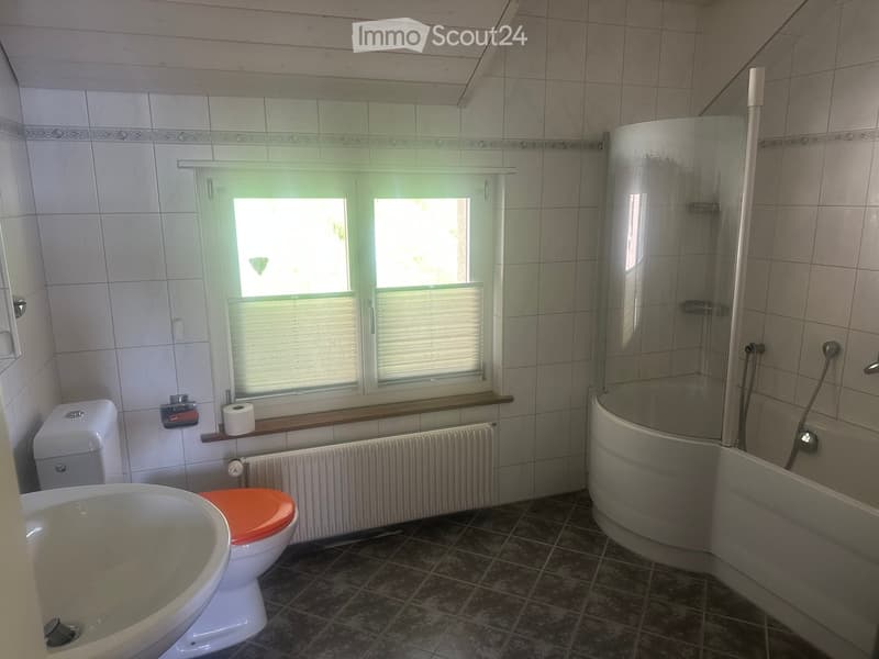 Bathroom with a toilet, bathtub, shower, radiator, and a window with blinds.