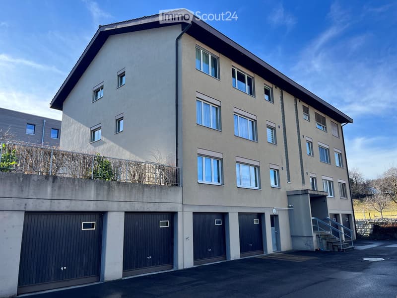 3 story building, dark grey walls, double glass windows, multiple balconies, underground garages
