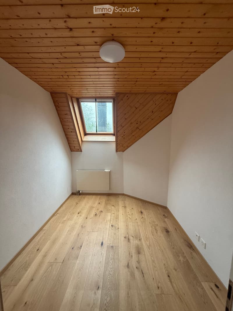 Wooden floor hallway with white walls, a skylight window, and a recessed ceiling light fixture.