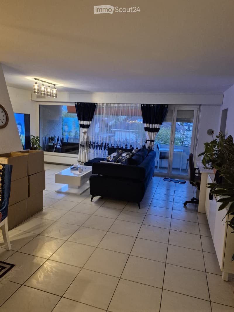 Living room with a couch, coffee table, and a balcony