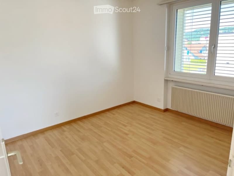 Empty room with wooden flooring, white walls, and a window with blinds. No furniture or equipment present.