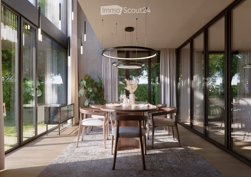 Modern dining room with a round wooden table, six chairs, a large pendant light, and large windows with curtains. A vase with dried flowers is on the table, and a cabinet is visible to the left.