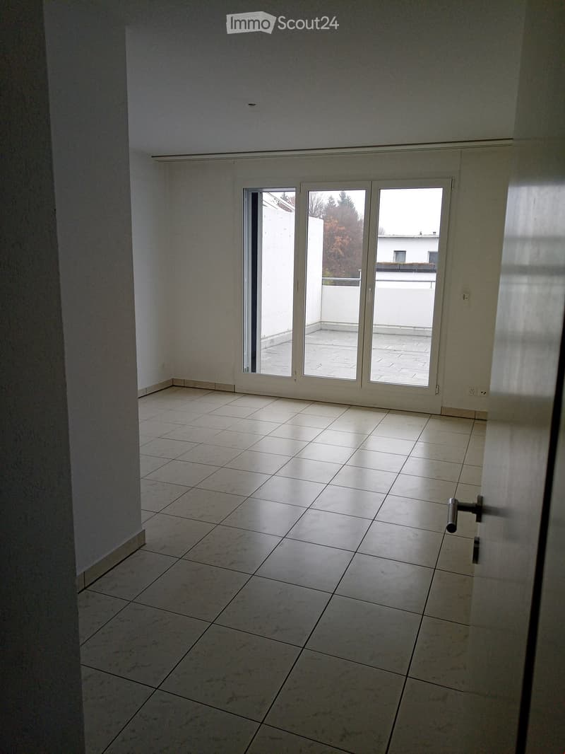 Empty room with tiled floor and large sliding glass doors leading to a balcony area.