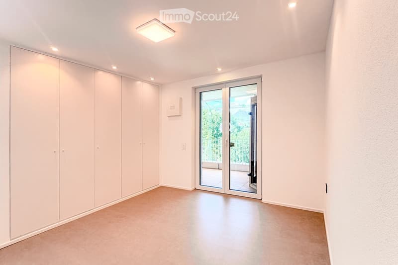 Unfurnished Room. Empty room with beige tiled floor, white walls, built-in closet, and large sliding glass doors leading to a balcony.