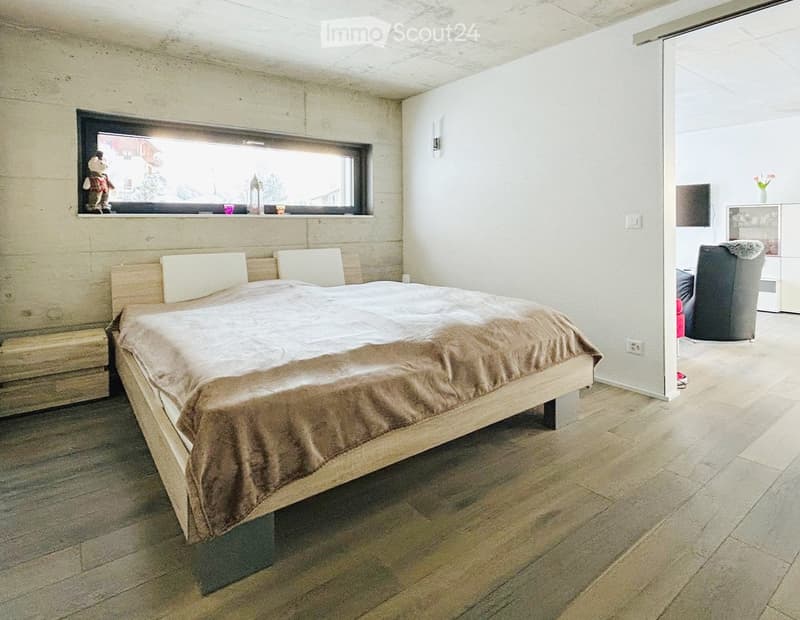Bedroom with bed, wooden floor, white walls, window, nightstands, interior door
