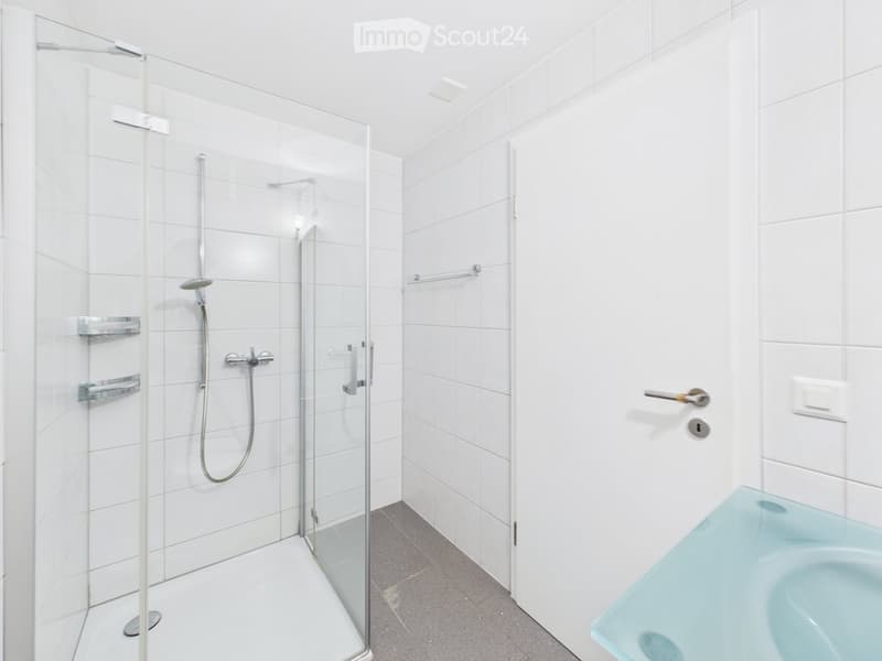 Modern bathroom with a glass-enclosed shower, a bathtub, and white tiled walls.