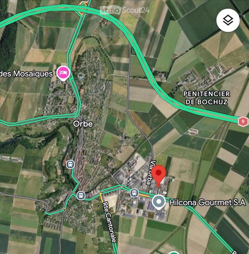 Aerial view of a rural area with roads, buildings, and agricultural fields. Key locations include 'Orbe,' 'des Mosaïques,' 'PENITENCIER DE BOCHUZ,' and 'Hilcona Gourmet S.A.'