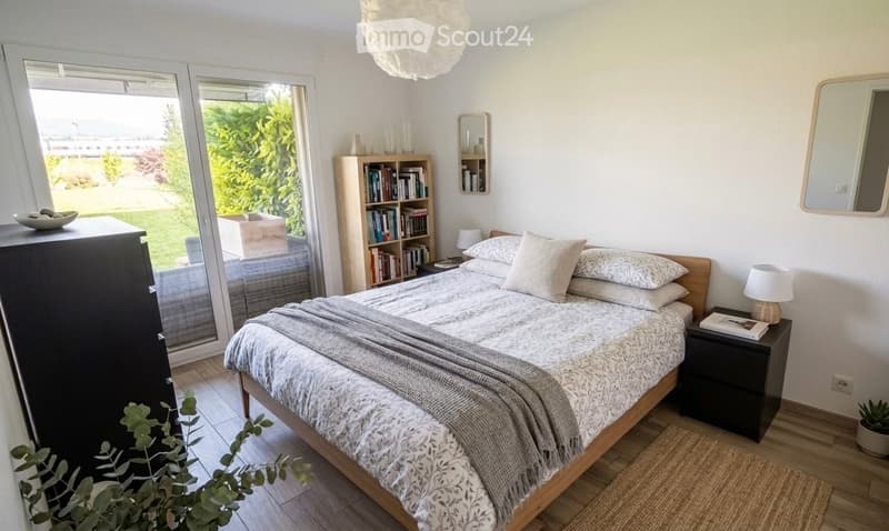 Cozy bedroom with a wooden bed, nightstand, bookcase, and large window with a view of greenery.