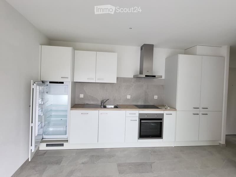 Modern kitchen with white cabinets, stainless steel appliances, and a light grey tiled floor.