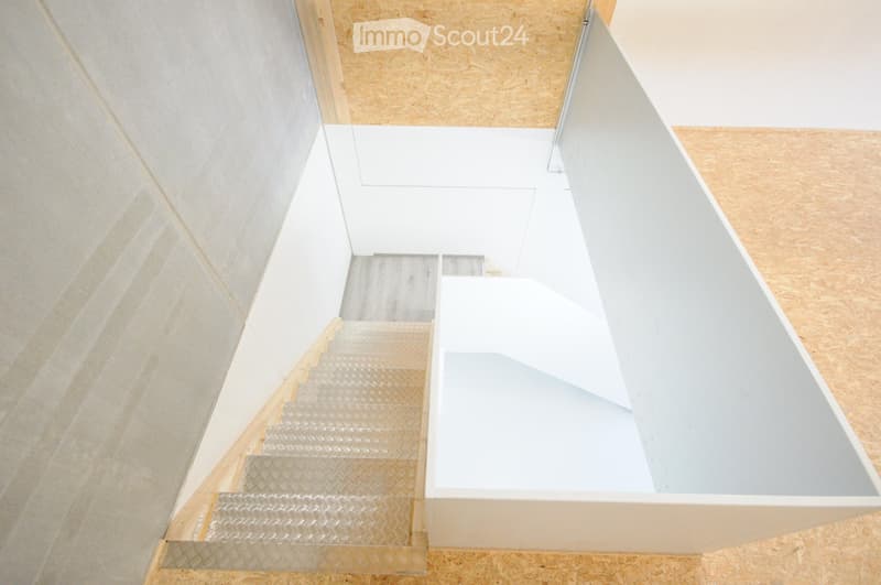 Modern, minimalist staircase with white walls and wooden steps, featuring a sleek, contemporary design.