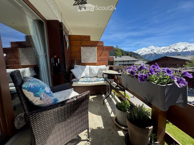 wooden terrace with sofa, table, plants and mountain view