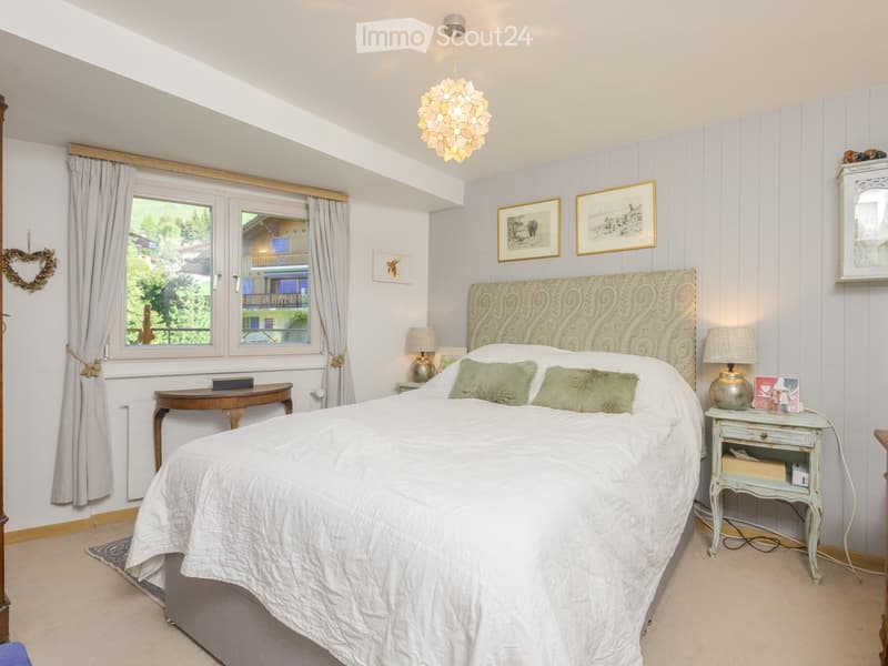 large bed, gray nightstands, lamps, curtains, radiator, window, lamps, pictures, decorative items, wooden table, mirror, lamp