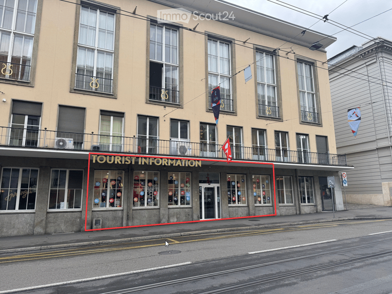 Multi-story building with large windows, a balcony, and a storefront labeled 'TOURIST INFORMATION' with promotional stickers on the windows.