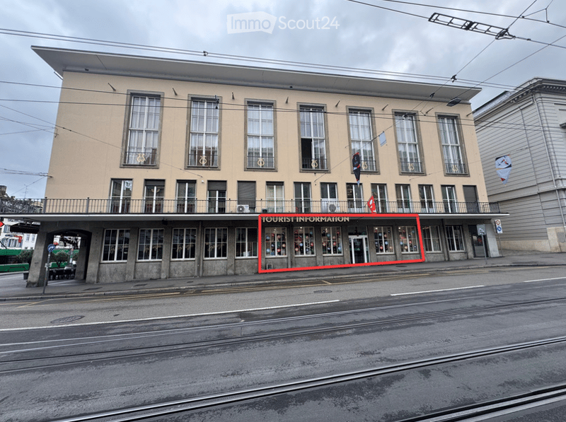 A multi-story building with a flat roof and large windows, featuring a sign that reads "TOURIST INFORMATION" on the ground floor.