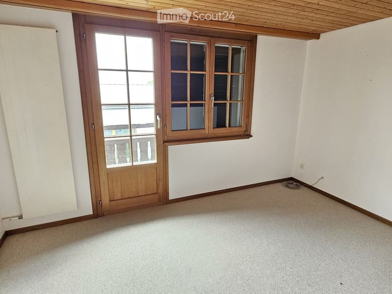 Empty room with beige carpet, white walls, and a wooden door with glass panels.